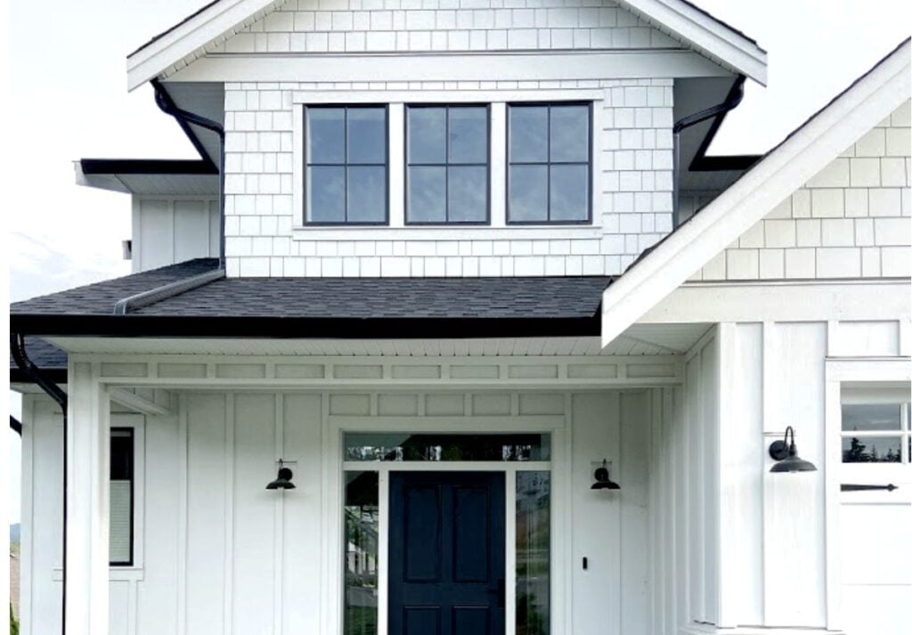 Hardi board Arctic White Exterior board and batten and shakes, black windows, Tricorn Black front door, painted whitewash brick, dark gray roof, black gutters