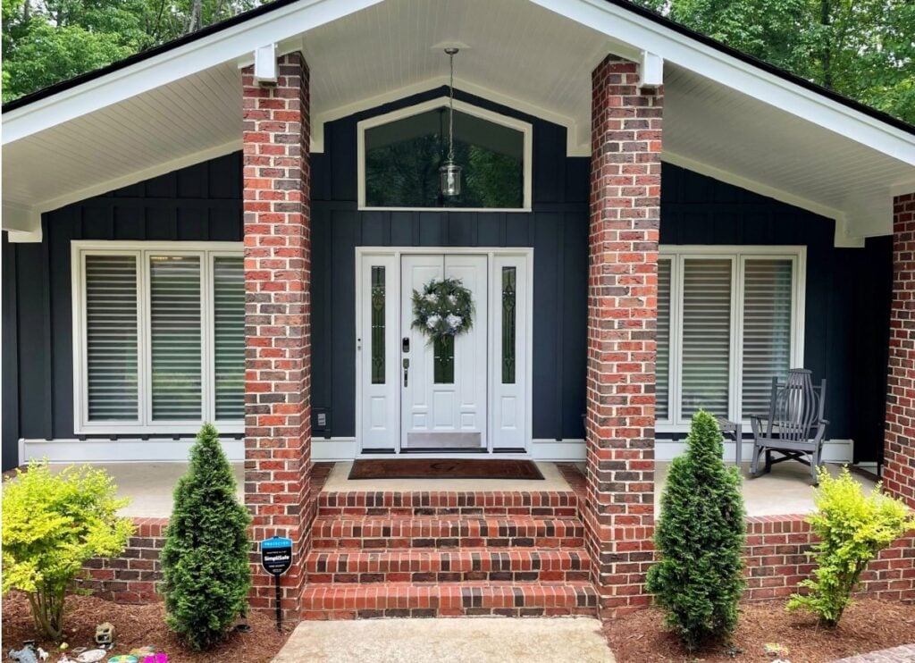 Hardiboard Iron Gray siding, dark gray-blue, red brick exterior, Sherwin Williams Extra White trim and front door, mid-century style subtle