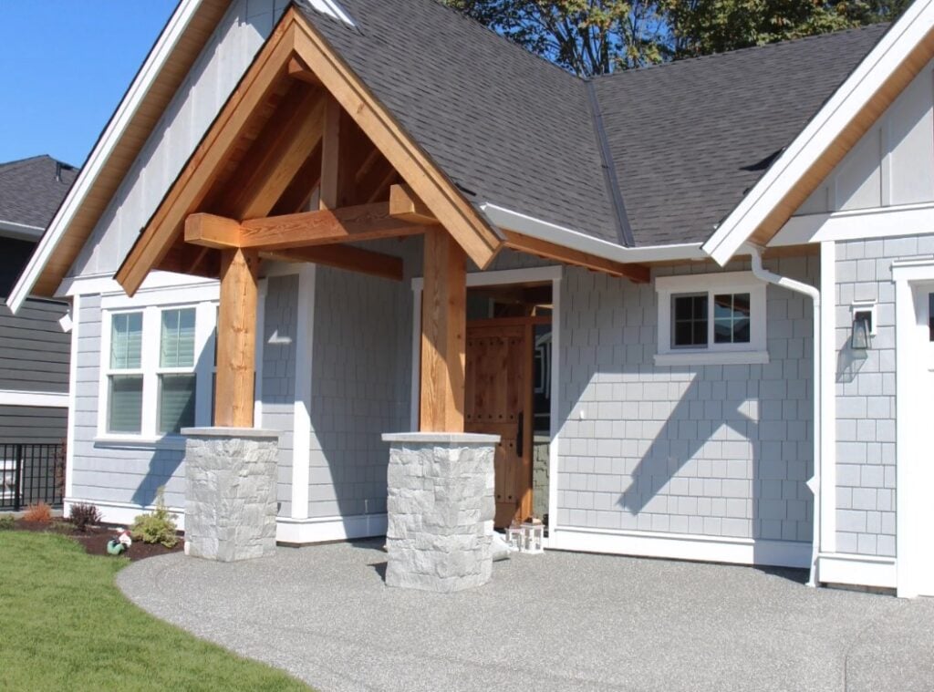 James Hardie LIght Mist exterior shake and board and batten, fir beams around front door, gray stone, High Reflective White trim, white windows, dark gray asphalt roof. Wood soffits