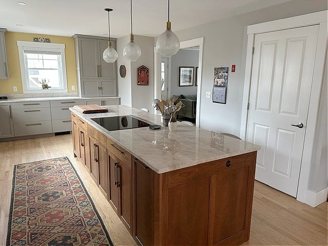 Kitchen, white oak flooring, wood stained island, Sherwin Williams Pavestone warm gray cabinets, Repose Gray and Da Vinci's Canvas gold yellow walls, Taj Mahal quartzite