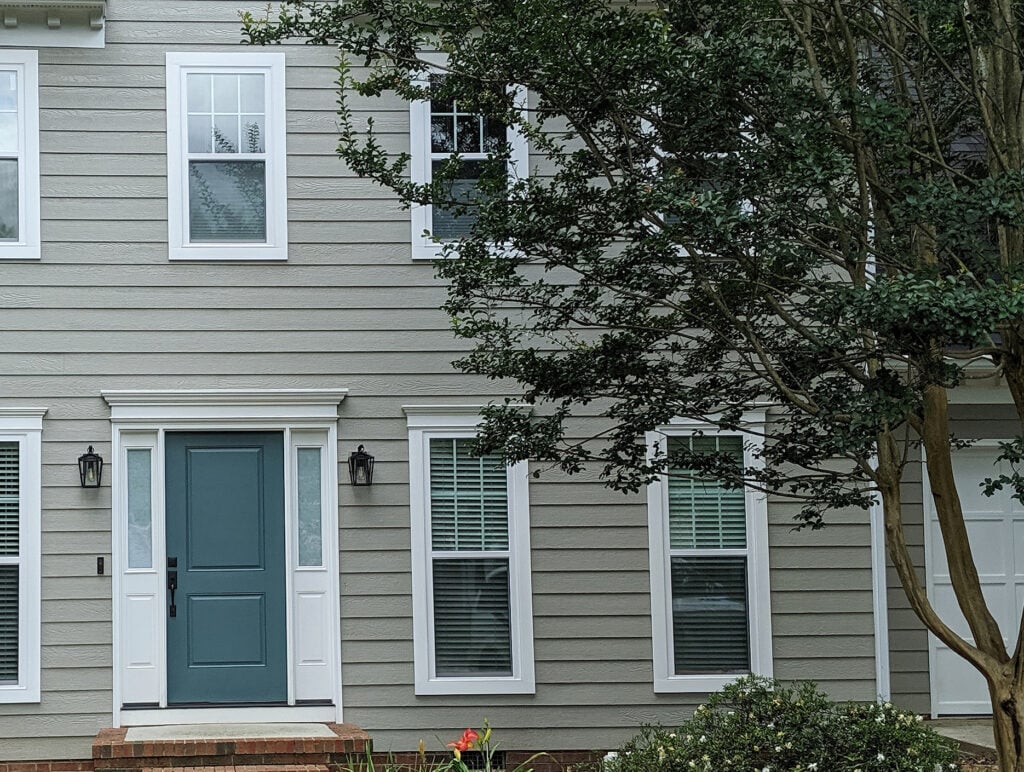 Sherwin Williams Extra White trim, teal green front door, Riverway, exterior of home painted Intellectual Gray. White windows.