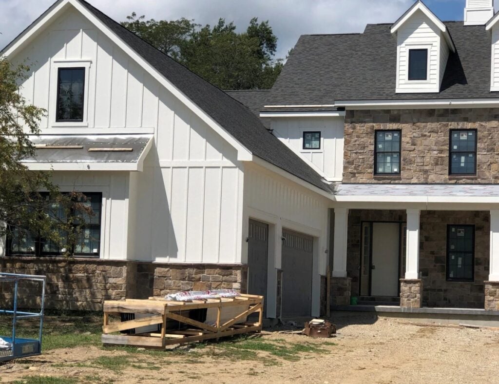Sherwin Williams Greek Villa painted exterior, board and battten, brown stone, black windows, best exterior white paint color