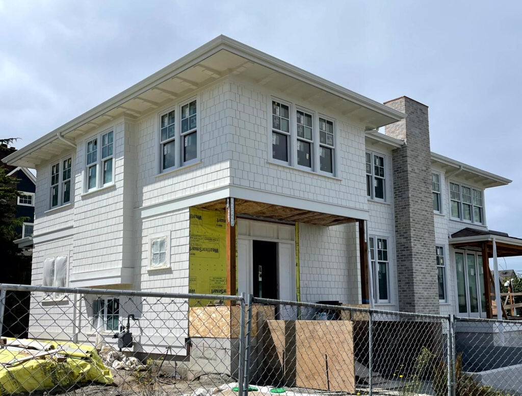 Sherwin Williams Pearly White warm off white on exterior, yellow undertone. Painted shakes white window and gutters