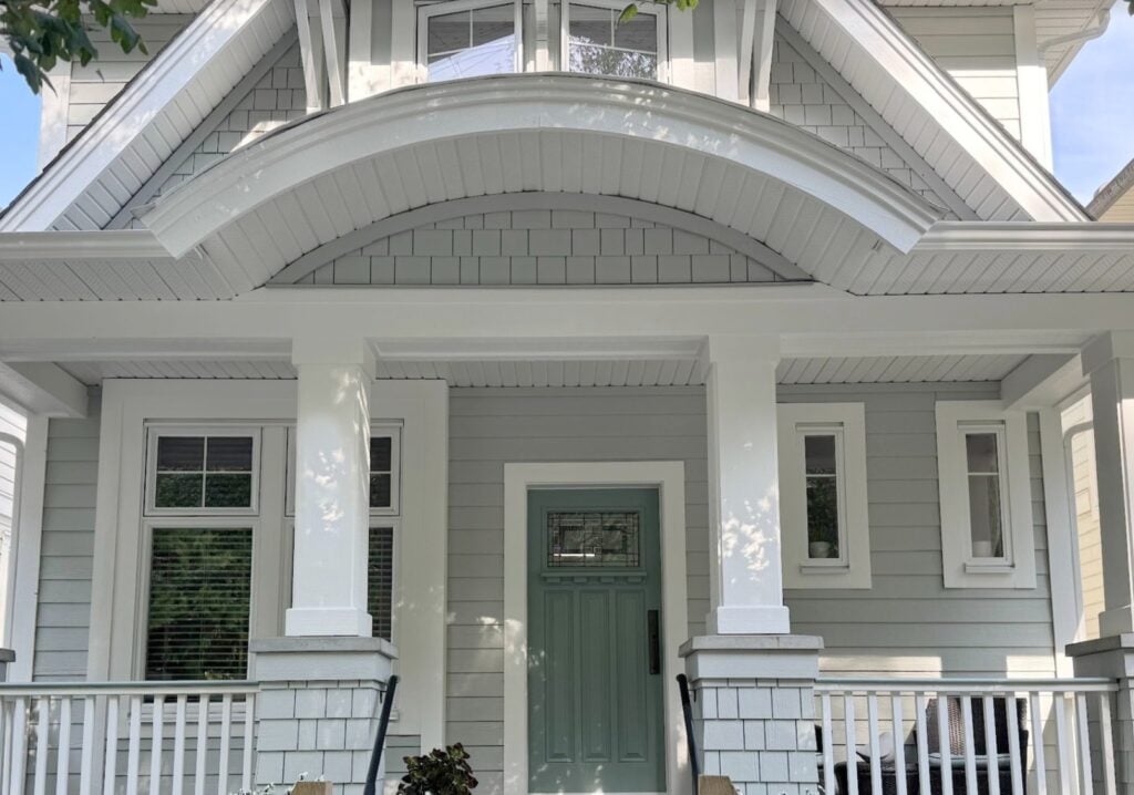 Sherwin Williams Pure White on exterior trim, white windows, Rushing River, blue-green front door, Gray Horse painted siding and shakes, curved portico