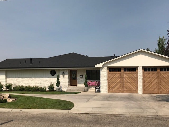 Sherwin Williams White Duck, warm creamy off-white exterior, painted brick, wood garage doors