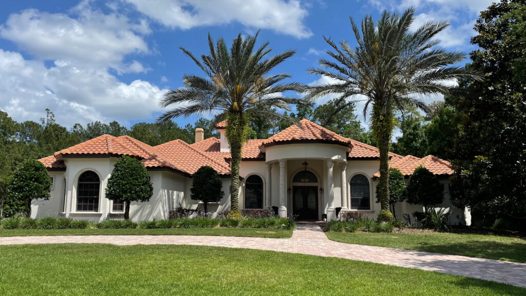 Sherwin Williams warm off-white paint color on stucco, balanced with red tile or terracotta tile roof on Mediterranean style exterior Florida home