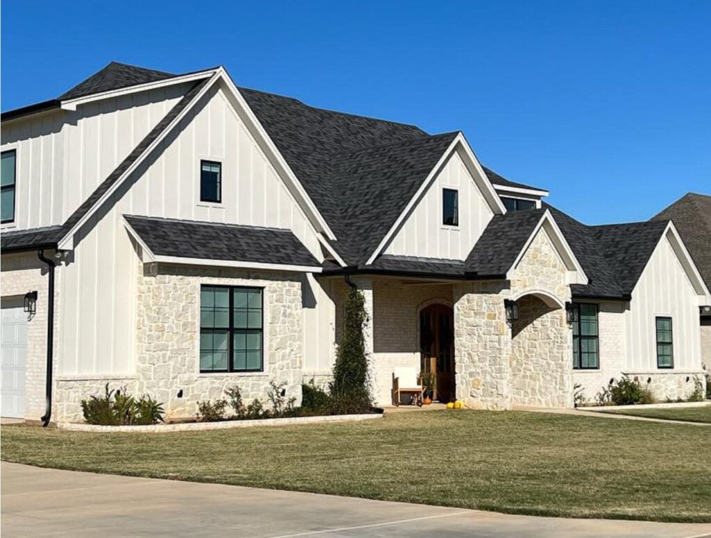 Sherwin Williams warm, off-white taupe with exterior with warm creamy beige stone, dark gray roof, black windows