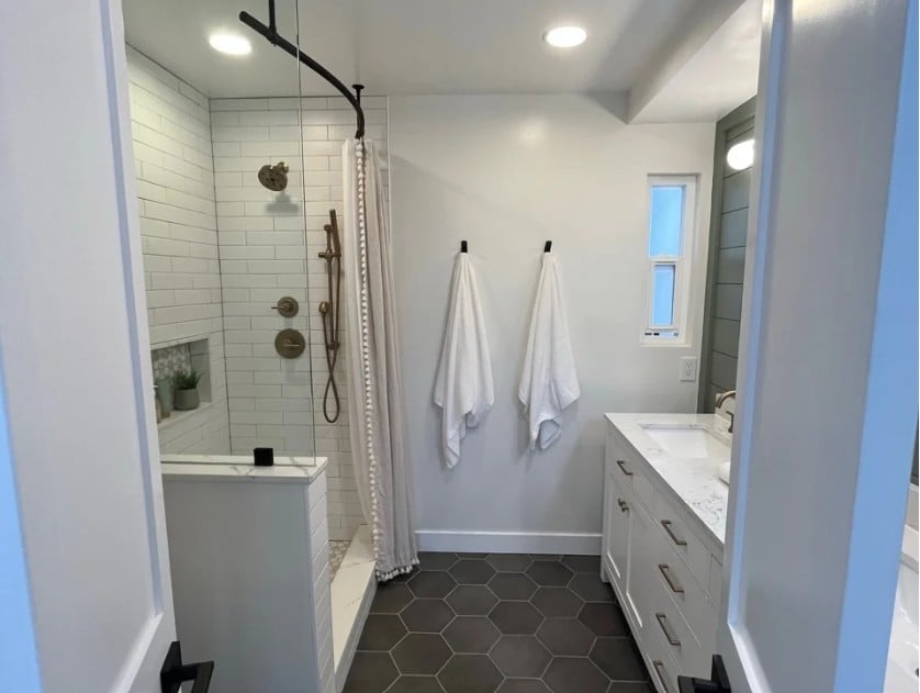 bathroom, dark gray hexagon tile flooring, low light, Sherwin Williams Alabaster walls, subwvay tile walk in shower creative shower curtain solution