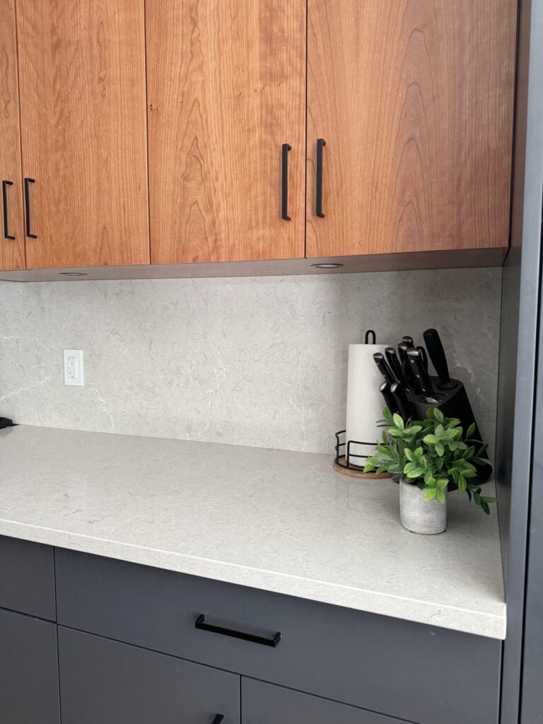 Benjamin Moore Cheating Heart painted kitchen cabinets, cherry wood slab panel doors, Caesarstone Bianco DRift quartz warm gray countertop, slab backsplash