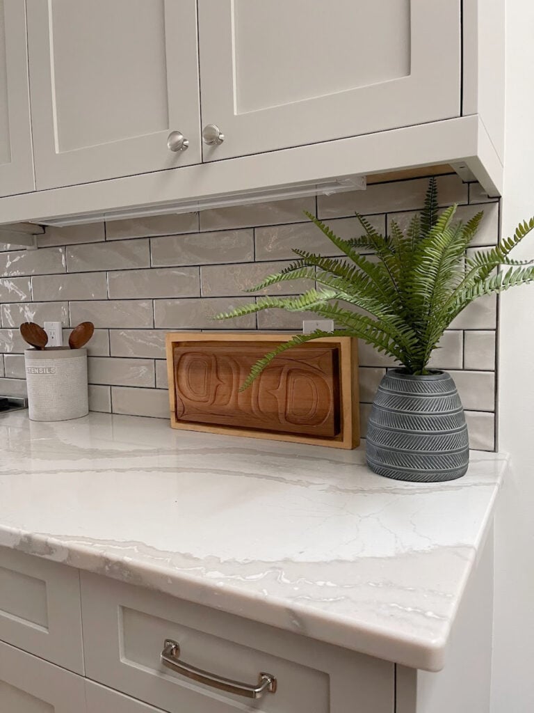 Benjamin Moore REvere Pewter painted kitchen cabinets Cambria Brittanica WArm quartz, off-white with taupe. Warm gray subway tile backsplash and hardware