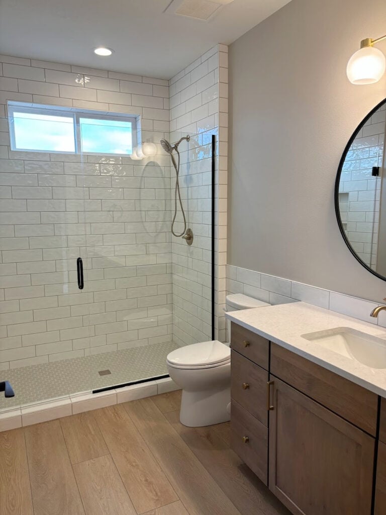 Sherwin Williams Agreeable GRay in small bathroom, wood look tile floor wood vanity, white subway tile i walk in shower - Copy