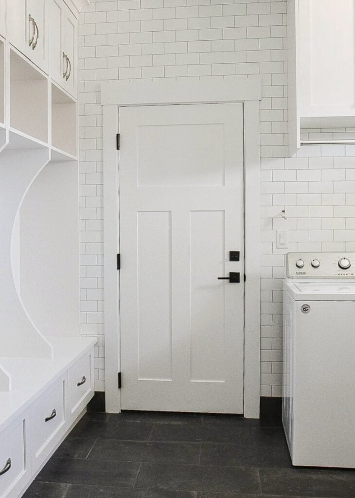 laundry and mudroom, Sherwin Williams High Reflective White with subway tile wall, cubbies and dark gray black tile flooring