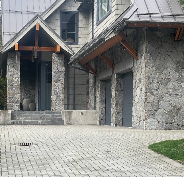 match the garage door to the darker trim with a gray-green house, metal roof and exterior stone (1)
