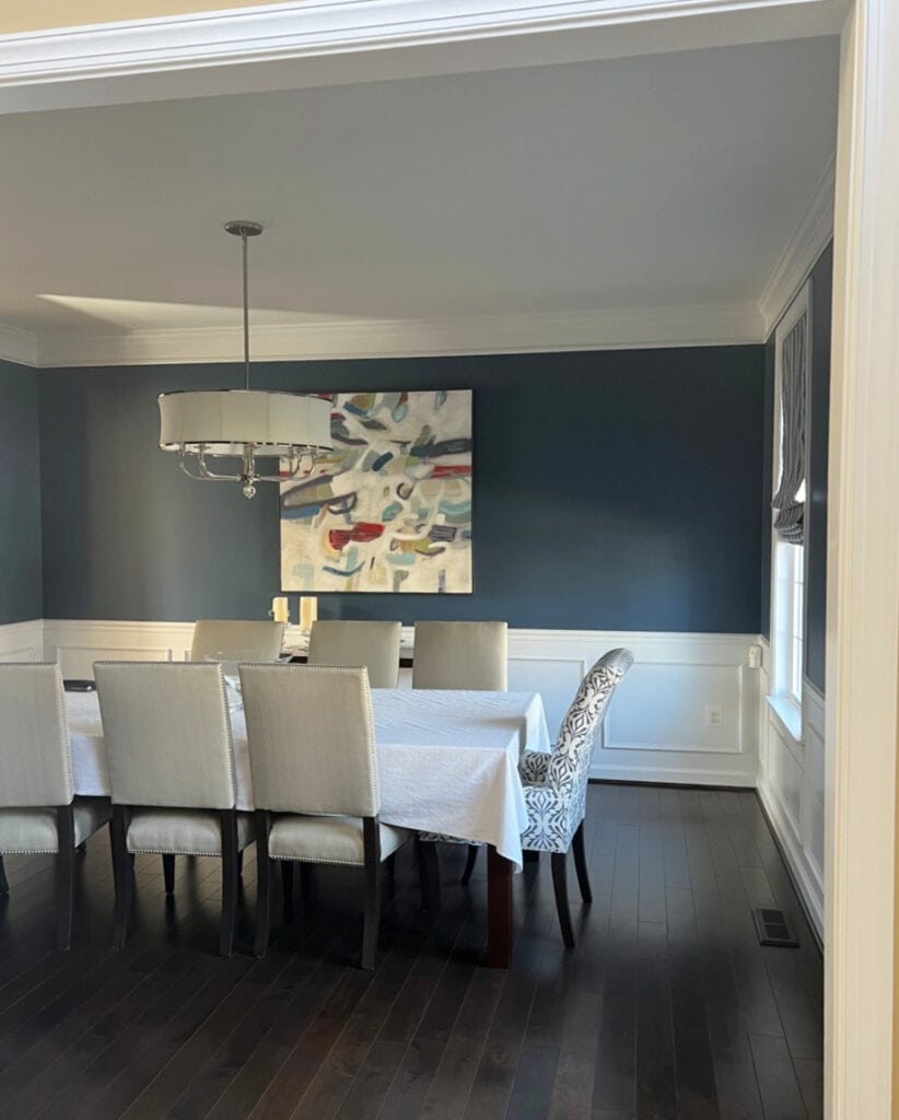 Benjamin Moore Van Deusen Blue in dining room with white wainscoting, dark wood floor