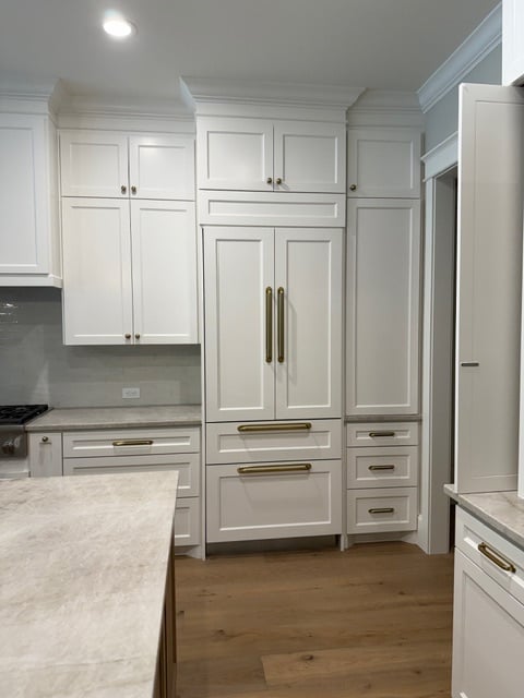 Sherwin Williams Alabaster warm white painted cabinets, wood floor with gold hardware, and Taj Mahal, Perla Venata Quartzite countertop