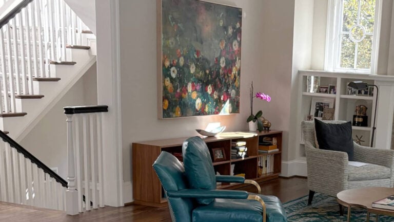 Living room walls painted Benjamin MOore Edgecomb Gray, White Dove walls with a teal leather chair and artwork