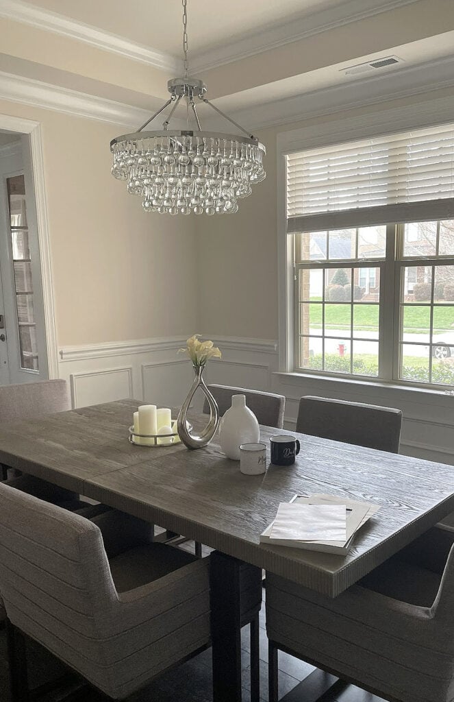 Sherwin Williams Divine White, warm beige paint color in dining room with tray ceiling and crown molding