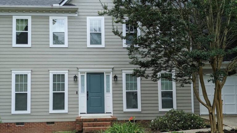 Sherwin Williams Intellectural Gray on exterior siding with red brick and a teal front door