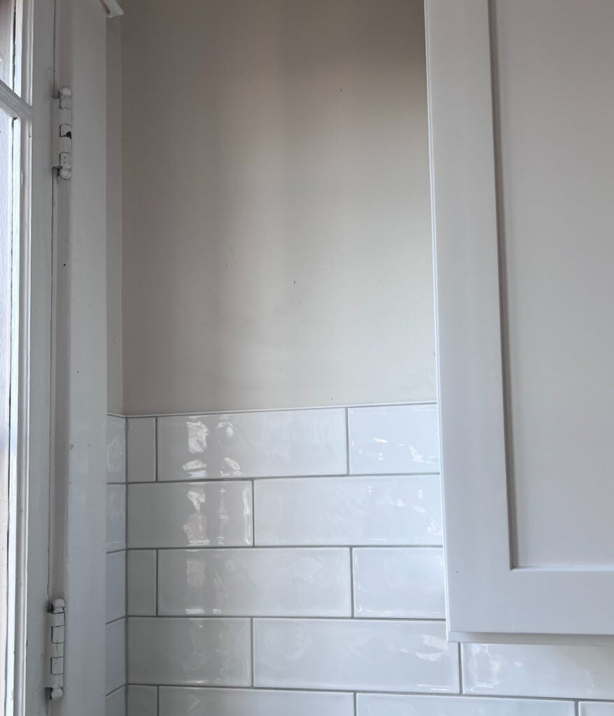 Sherwin Williams Origami White with Extra White trim and cabinets and white subway tile with gray grout