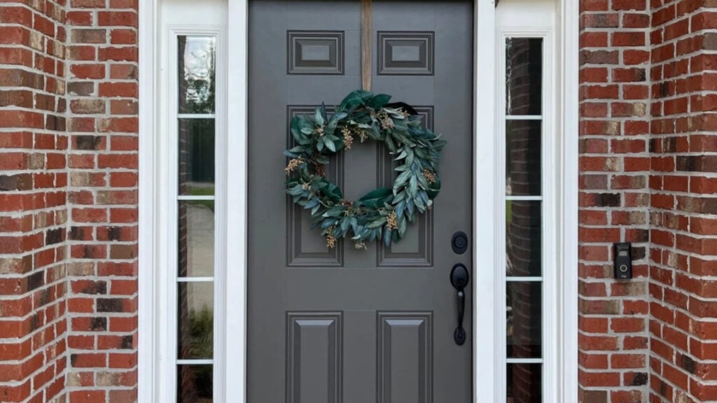 brick exterior, red brick with black, dark greige paint color on the front door on low natural lighting