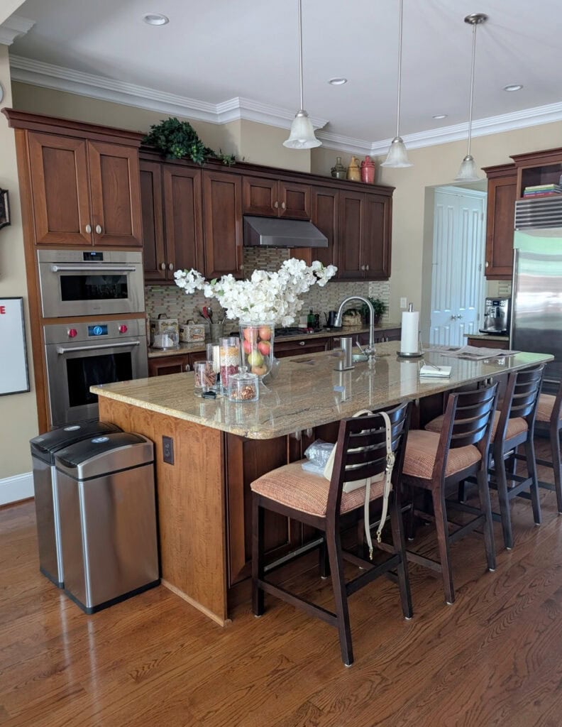 2000 gold warm granite countertops, oak flooring, wood cabinets (maple or cherry), travertine tile patterned backsplash with Sherwin Williams Basket Beige walls, north-facing kitchen