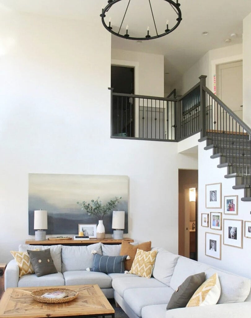 Livingroom that's north-facing with White Dove walls, high, vaulted ceiling and gray sectional