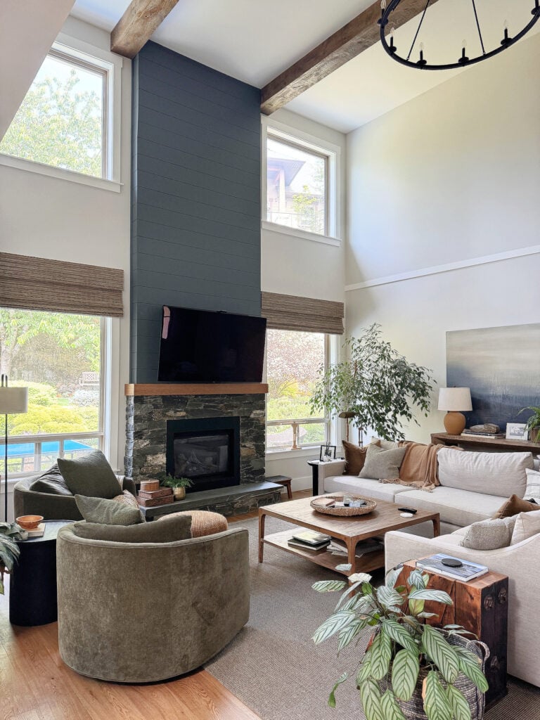 Sherwin Wiliams Aesthetic White in living room with high, vaulted ceiling and shiplap and K2 stone fireplace, sectional and pottery barn green accent chairs. North facing (2) (2)