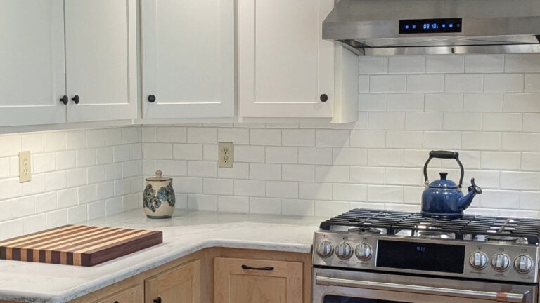 Sherwin Williams Alabaster, warm white kitchen abinets with subway tile, quartz, and light wood lower cabinets