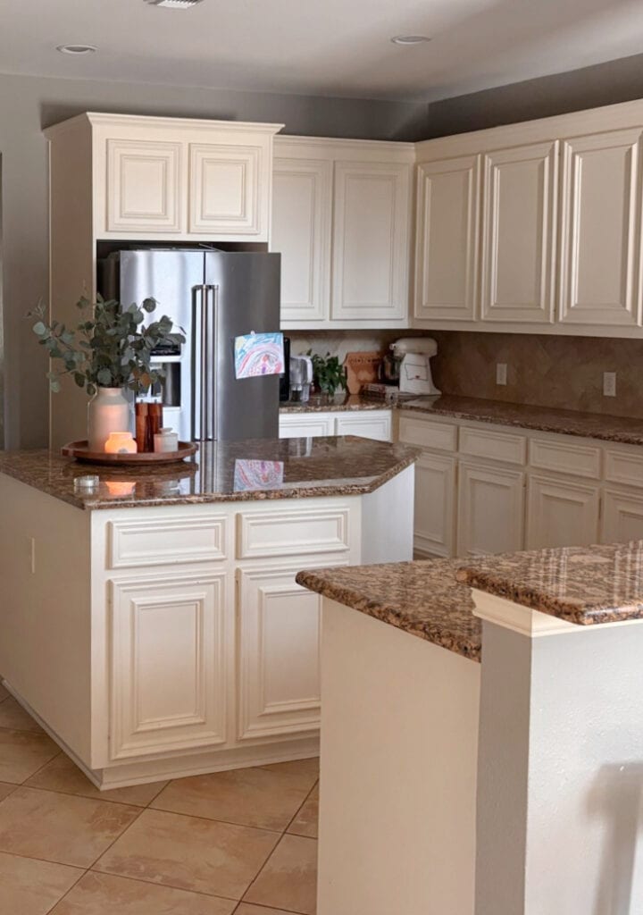 Sherwin Williams Antique White kitchen cabinets, orange peach granite countertops, early 2000s beige tile floor, island. (1)