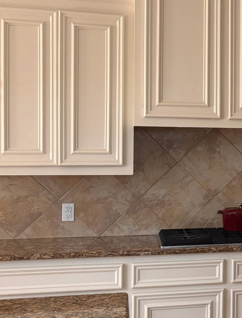 Sherwin Williams Antique White painted kitchen cabinets and cream trim, orange and brown granite countertop, tile backsplash (1)