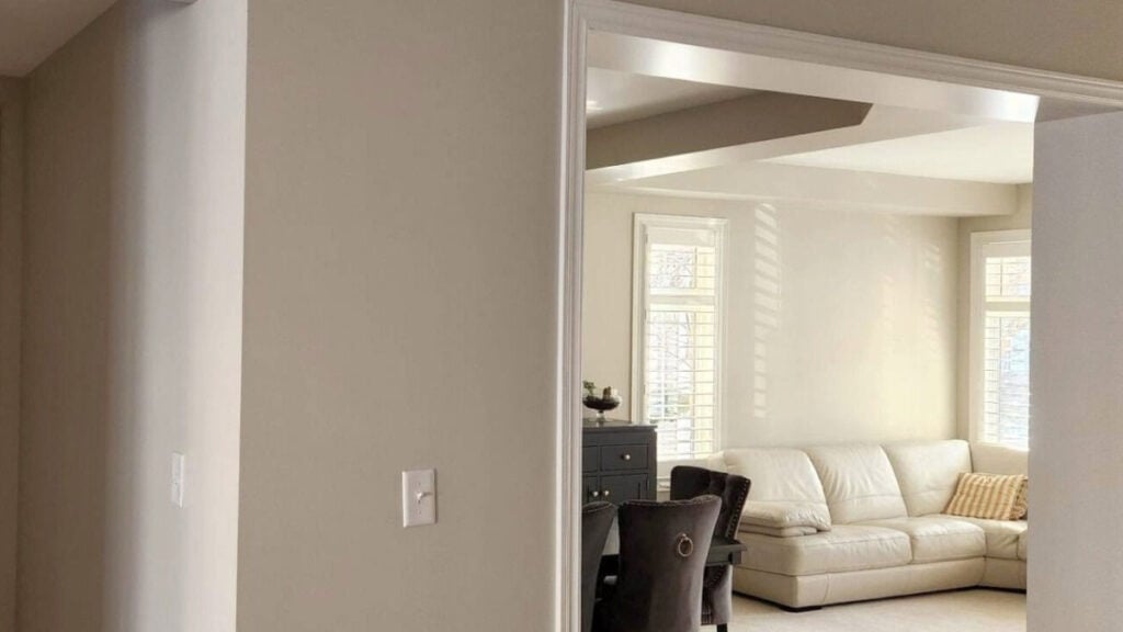BEnjamin Moore Natural Cream in rooms with west-facing and east-facing exposure, taupe carpet and cream leather sofa.