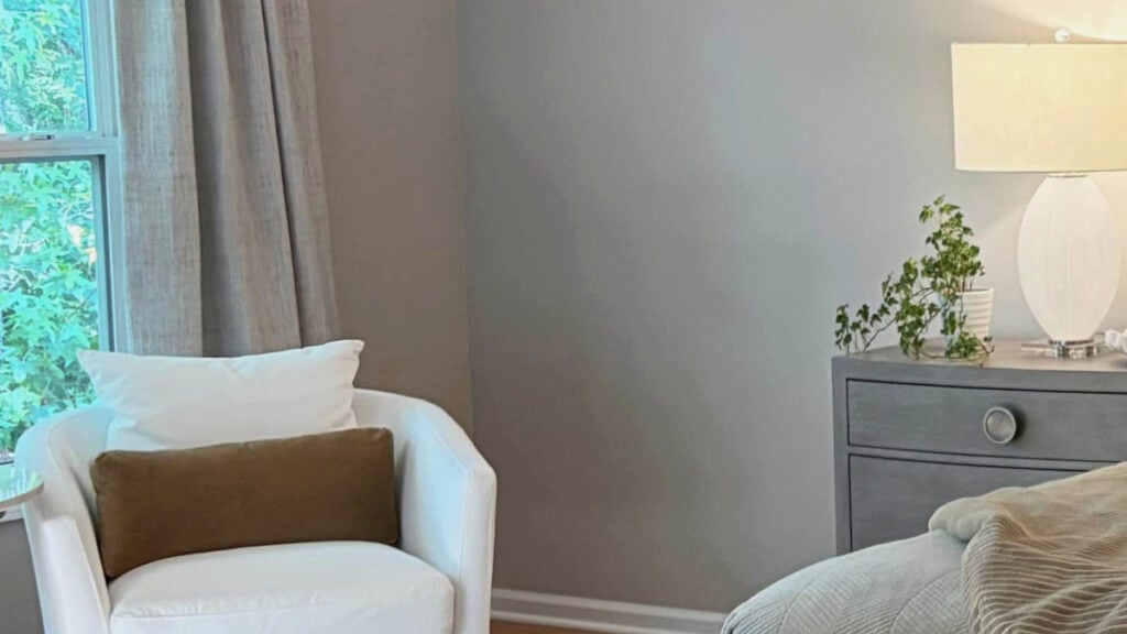 Sherwin Williams POpular Gray in bedroom with north-facing natural light, off-white accent chair and drapes