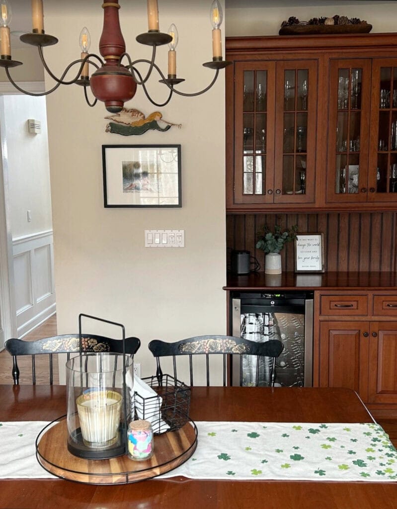 Benjamin Moore Edegecomb Gray in north-east facing natural light, dining area of kitchen with white trim, Dark cherry toned wood kitchen cabinets.
