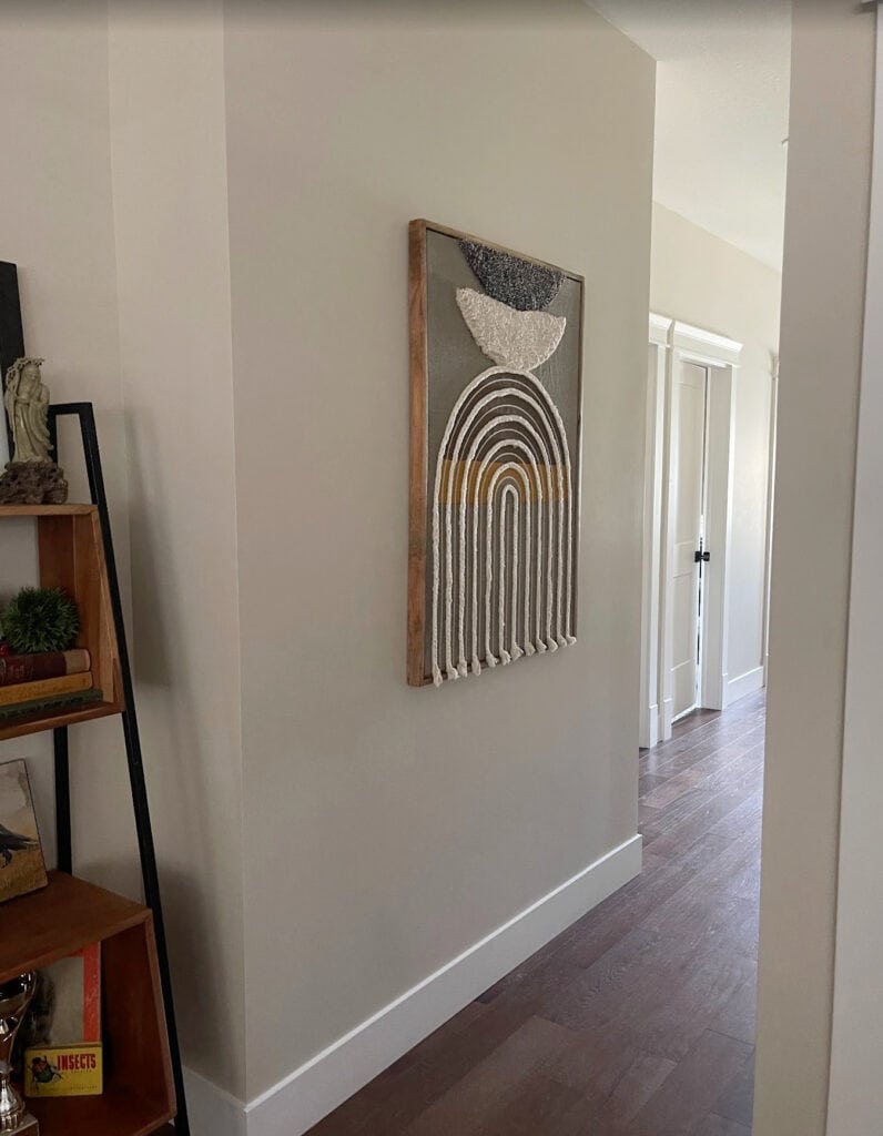 Benjamin Moore Manchester Tan in hallway with dark wood floor, Cloud White trim, natural light