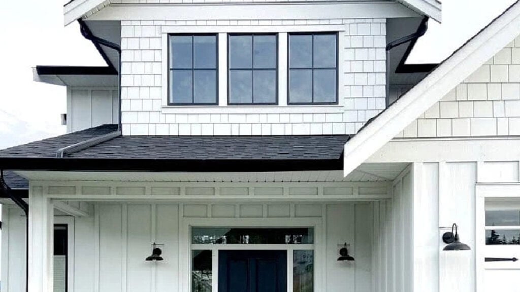 James Hardie Arctic White exterior board and batten, shakes, and white brick with black door, windows, gutters and asphalt roof