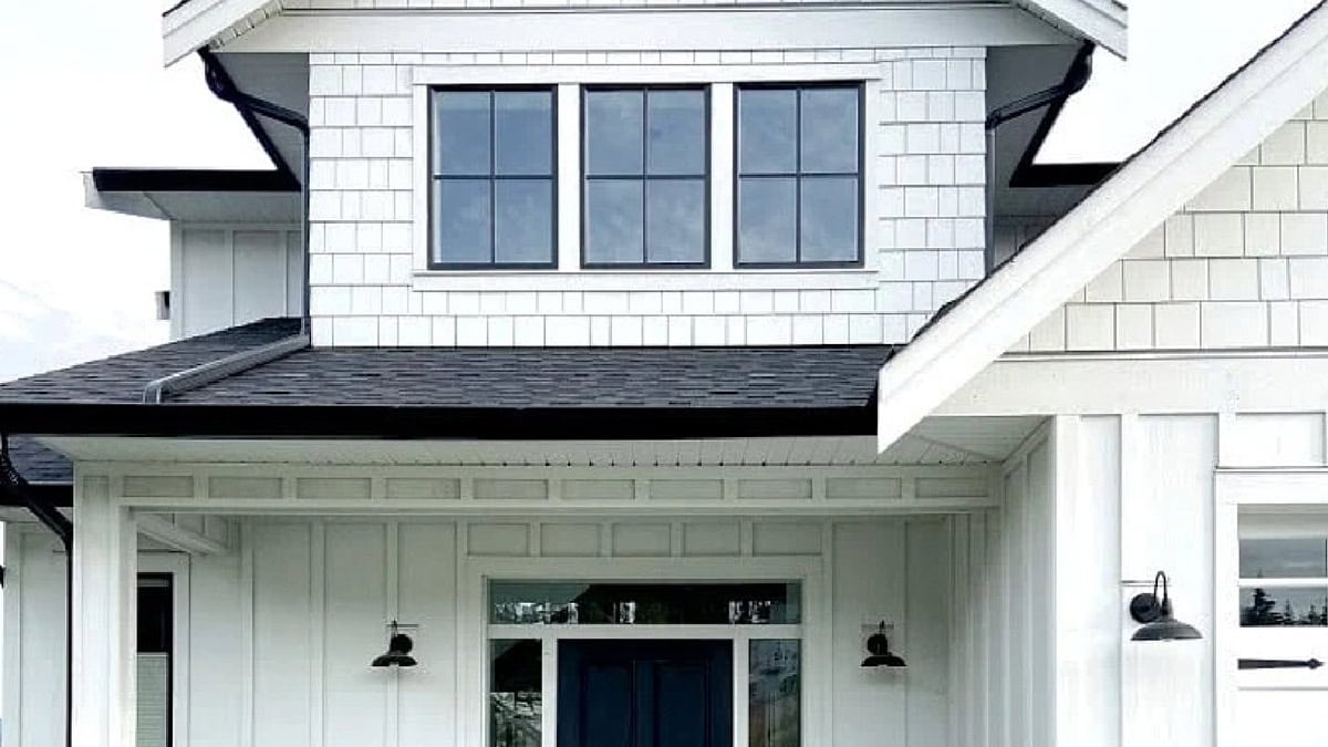 James Hardie Arctic White exterior board and batten, shakes, and white brick with black door, windows, gutters and asphalt roof