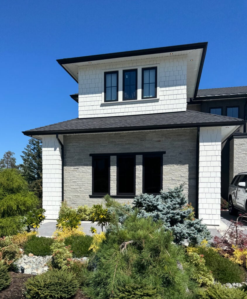 James Hardie Arctic White shakes on full sun south-facing exterior, warm gray stone, black windows, black gutters