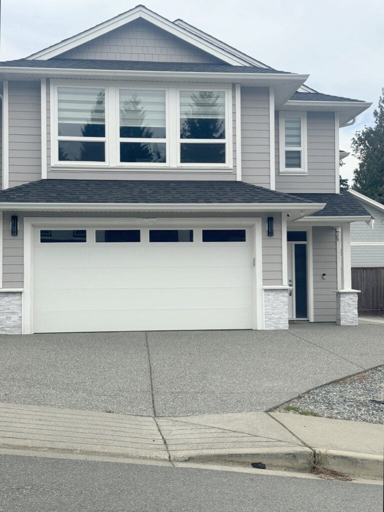 James Hardie Pearl Gray siding and shakes on exterior with white trim, dark gray black roof and white gutters