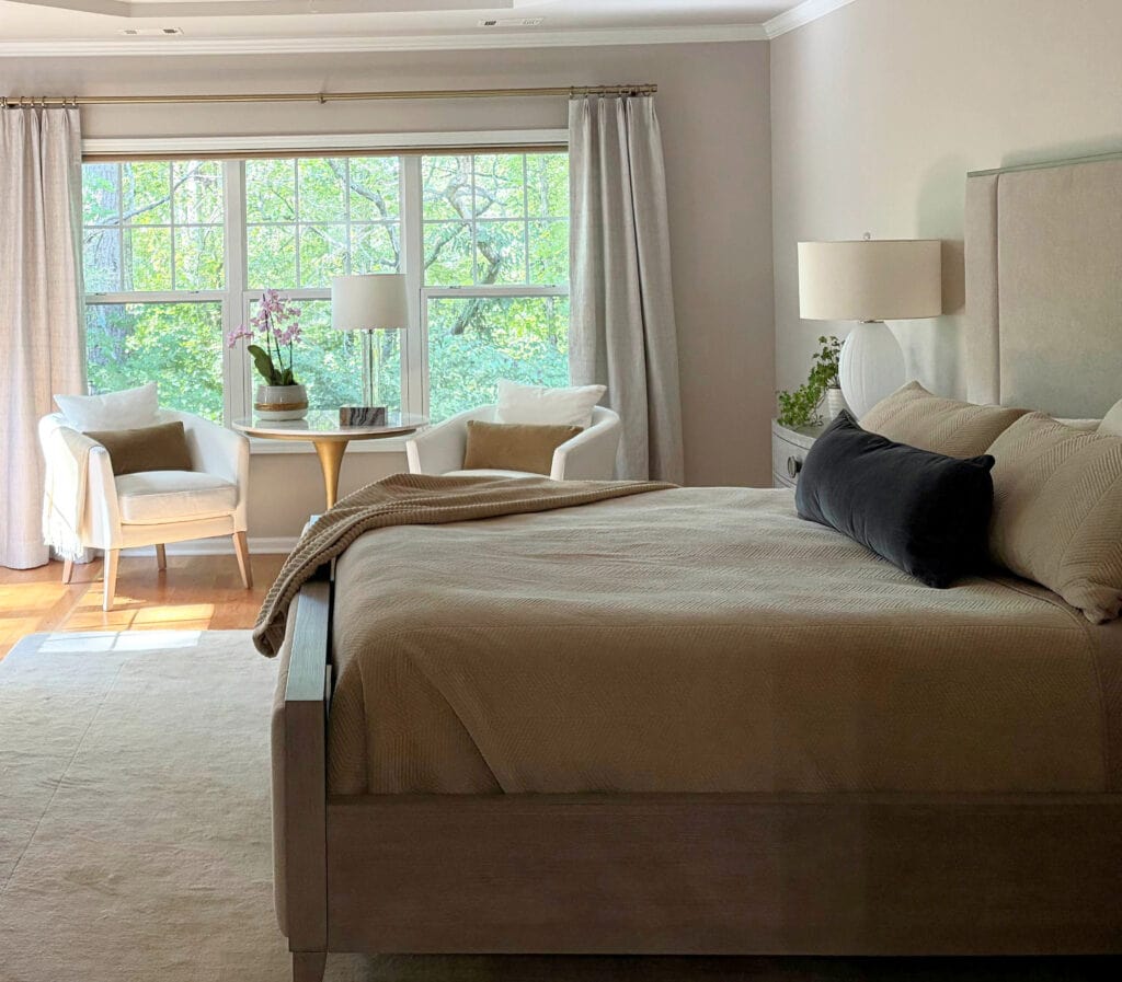 NOrthwest facing primary bedroom with Sherwin Williams POpular Gray walls, Pure White trim, accent chairs by window
