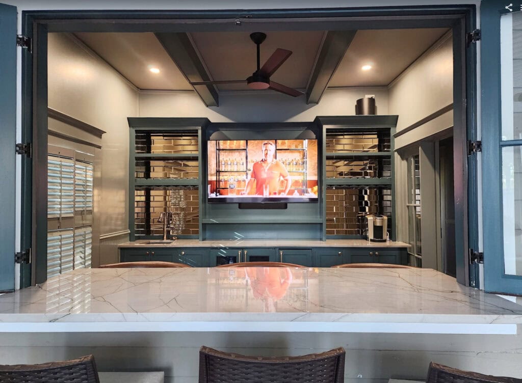 Ridgegate off-white warm gray quartz countertpo with home bar with window folding open to the inside. Trim and bar cabinet painted Sherwin Williams Still Water