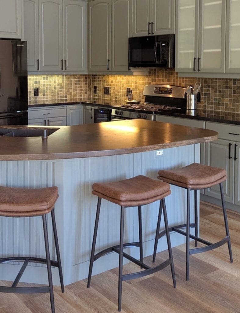 Sherwin Williams Attitude Gray (green-gray) painted kitchen cabinets, dark wood butcher block rounded island. Black granite perimter countertop, slate tile backsplash, black apliancesa