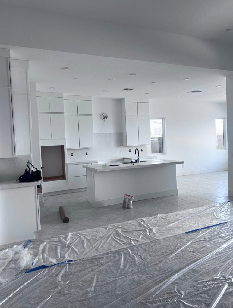 Sherwin Williams Pure White in east-facing afternoon light, gray tile floor in kitchen with modern, flat panel cabinets