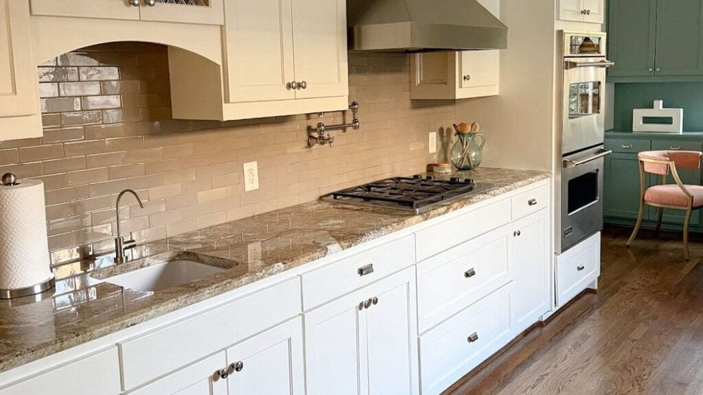 Sherwin Williams warm, creamy white cabinets with older granite countertop, taupe subway tile backsplash