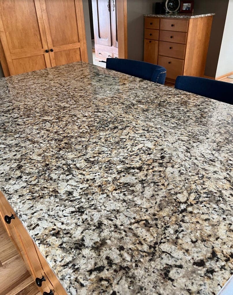 Speckled, busy white taupe, warm gray, black, beige and gold granite countertop from early 2000s
