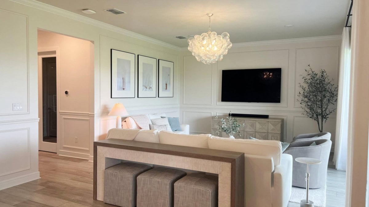 Benjamin Moore Dove Wing in transitional style living room wiht PUre White trim, molding on walls with TV and neutral furniture