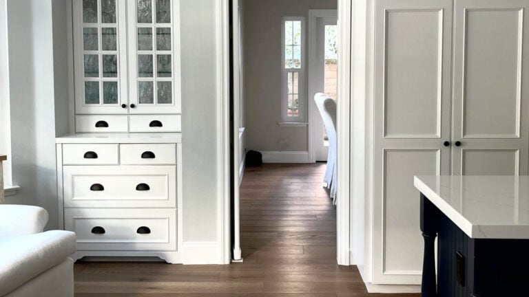 Benjamin Moore Chantilly Lace painted, traditional and timeless kitchen casbinets with oak floor and Alaskan Husky on the walls
