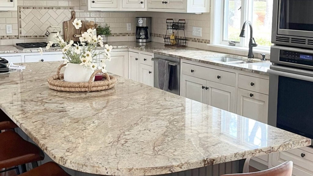 Cream and glazed 2000s kitchen cabinets with warm granite countertop and creamy subway tile backsplash
