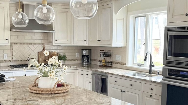 Kitchen with cream glazed cabinets, creamy subway tile backsplash and 2000s granite countertops, updated with small details